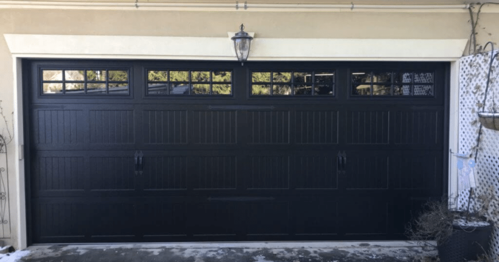 Black carriage-style garage door with glass.
