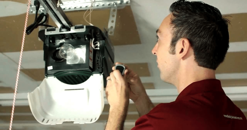 Man programs ceiling garage door opener.